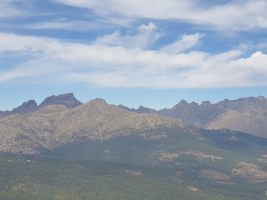 Links Capo Tafonatu (2335, mit erkennbarem Felsentor) und Paglia Orba (2525); dazwischen liegt der heutige Startpunkt, das Refuge de Ciottolu di i Mori. Rechts der vorgelagerten Punta di Licciola (2235) markant die Punta Minuta (2556), dann Capu Rossu (2498) und die doppelgipflige Capu Larghia (2475). Weiter die runde Pointe d´Éboulis (2607) und rechts aussen schliesslich der Monte Cinto (2706). [imgDir=NNE alt=1750]