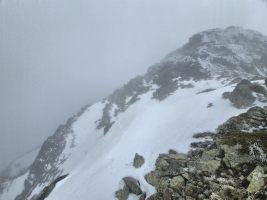 Steiles Schneefeld über die Felsen umgehen